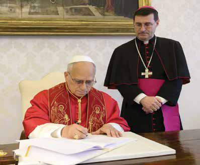 Léon XIV signant l’encyclique Magnifica humanitas le 15 mai 2026 au Vatican, accompagné de Mgr Paolo Rudelli, substitut pour les Affaires générales de la Secrétairerie d’État.